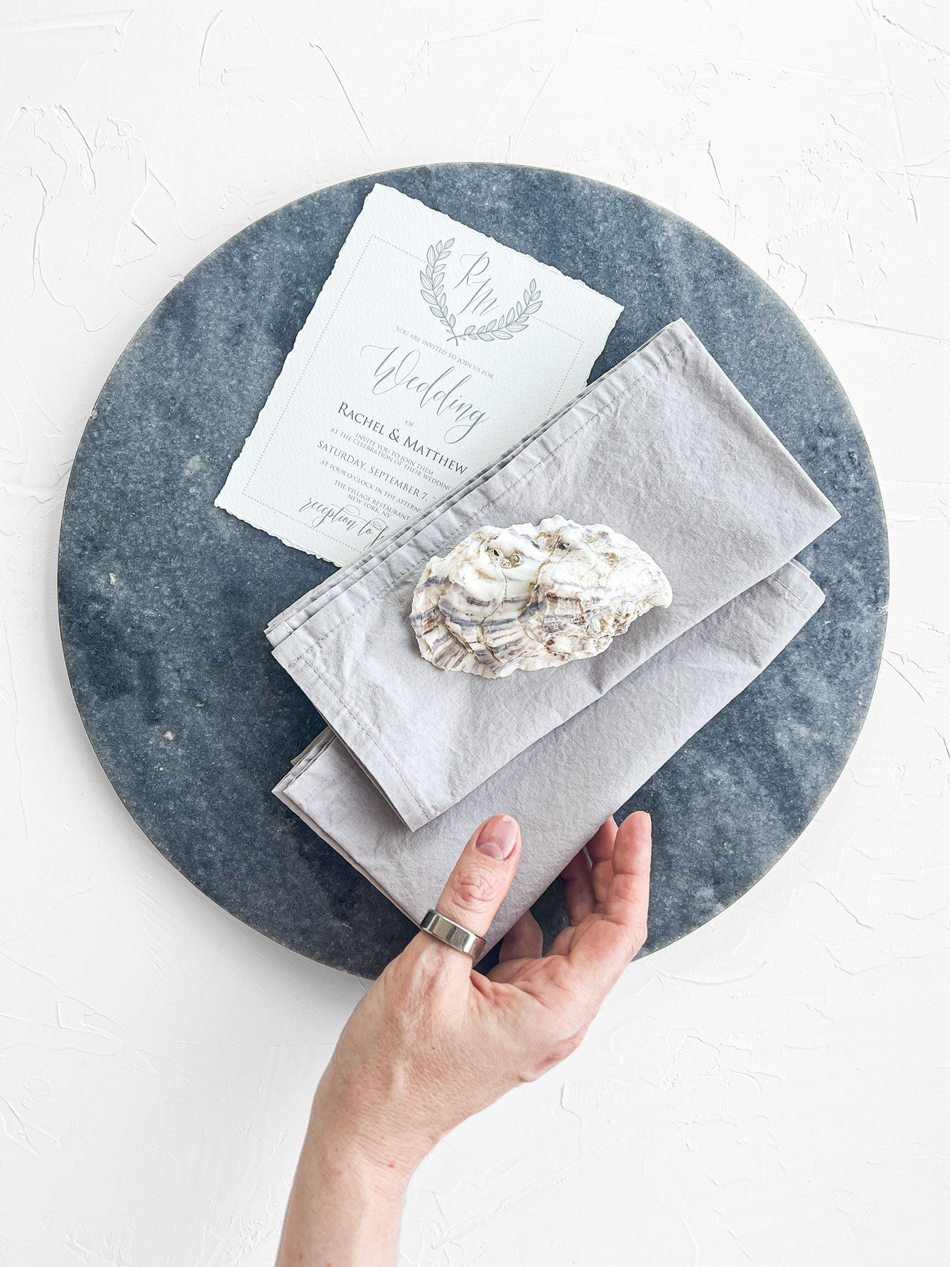 Light grey hand made cotton napkins set on wedding invitation