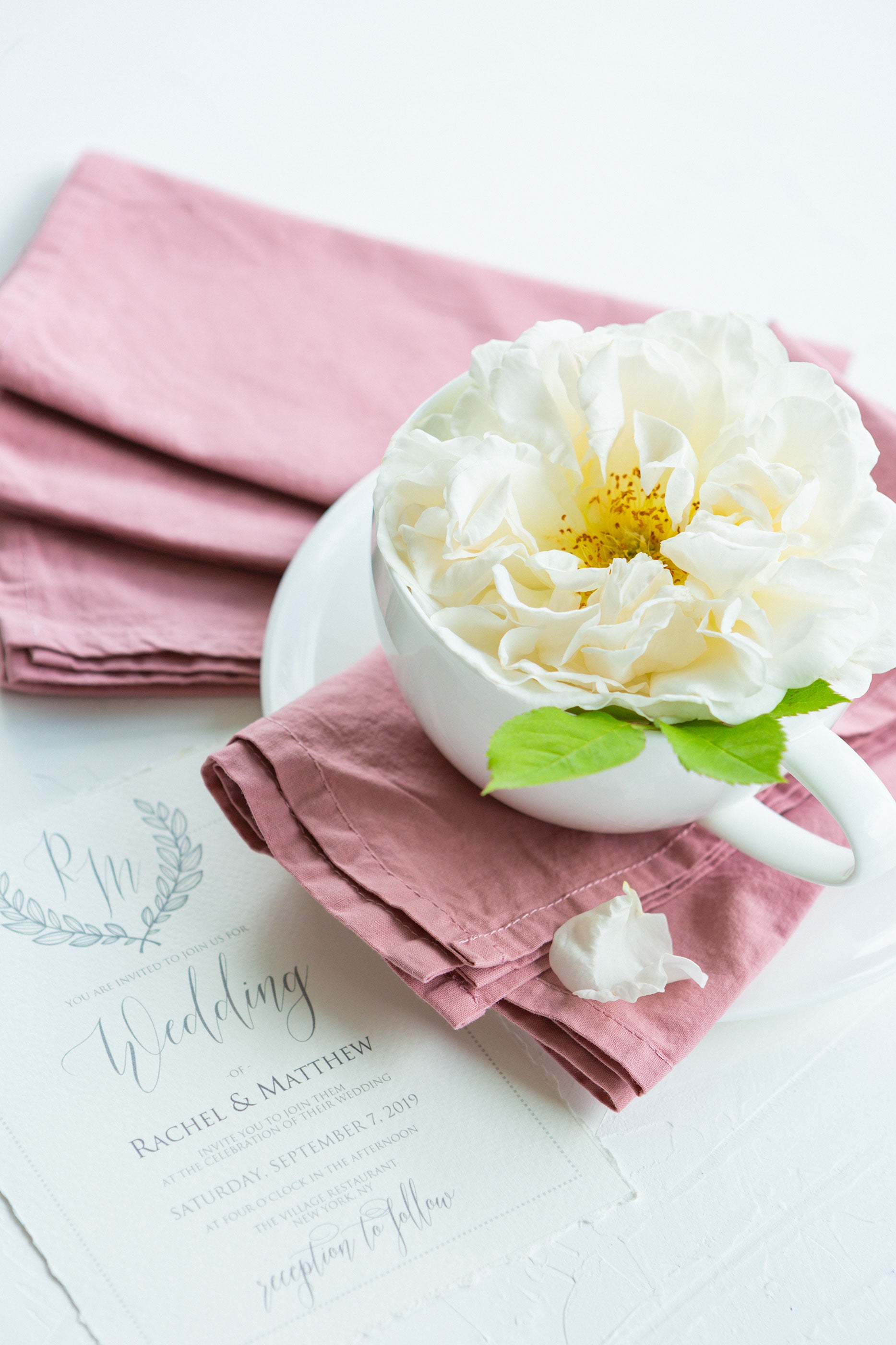 Dusty rose mauve dinner napkins on wedding invitation